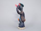 figurine of a man with a hat on his head holding a string