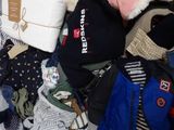 a pile of clothes that is sitting on a bed