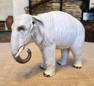 statue of an elephant on a table with a fireplace in the background