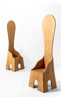 deux chaises en bois assises l'une à côté de l'autre sur une surface blanche