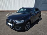 L'Audi Q3 est garée sur un parking près d'un immeuble.