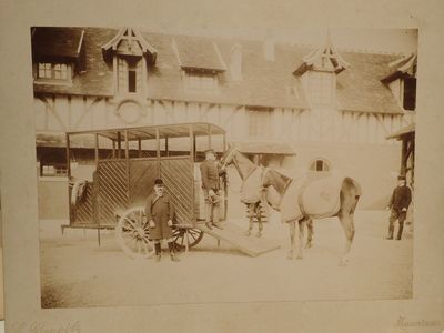 an old photo of a horse pulling a cart with a man standing next to it
