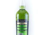 a bottle of green liquid sitting on top of a white surface