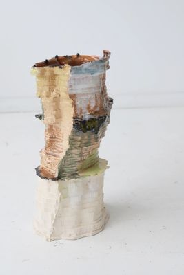 un petit vase surmonté d'un morceau de bois