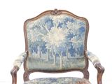 a blue and white chair with a floral upholstered back