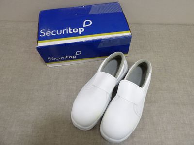deux paires de chaussures blanches posées à côté d'une boîte de Securitop