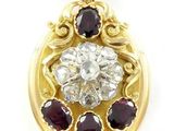un gros plan d'un pendentif en or jaune serti d'un diamant et de grenats