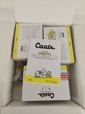 trois paquets de cigarettes posés dans une boîte posée par terre