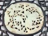 a white and black plate with a carved design on it