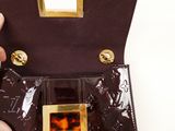 someone is holding a brown purse with a gold buckle on it