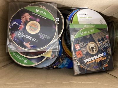 beaucoup de DVD dans une boîte en carton posée sur la table