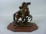 statue en bronze représentant un homme à cheval accompagné d'une femme à cheval