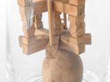 a small wooden object in a glass jar on a table