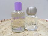 purple bottle of perfume next to a glass bottle of perfume