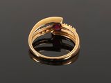 a close up of a gold ring with a ruby stone