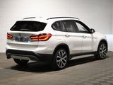 the rear end of a white bmw suv parked in a garage
