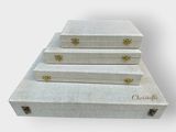 three white trunks stacked on top of each other on a white surface