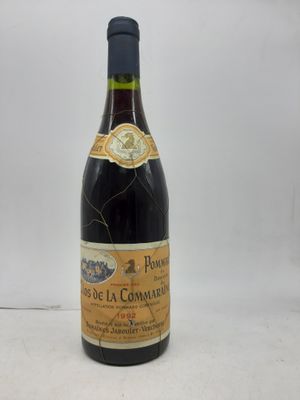 une bouteille de vin posée sur une table, devant un fond blanc