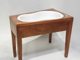 a small wooden table with a white bowl on it