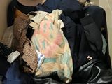 a box full of clothes and a hat on the floor