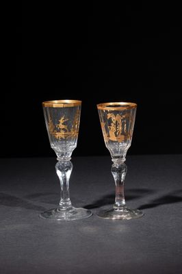 pair of crystal goblets with gold rims on a black background