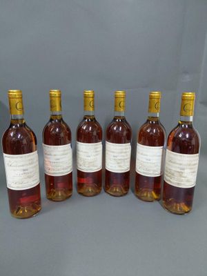 six bouteilles de vin sont alignées sur une table