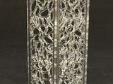 a glass vase with a design on it on a black surface