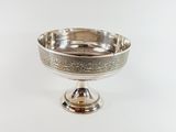 a silver bowl on a stand on a white surface