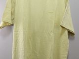 a yellow t - shirt hanging on a hanger on a wall