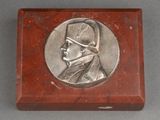 an image of a silver medallion of a man in a military uniform
