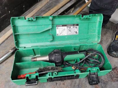a green tool box with tools in it on the floor