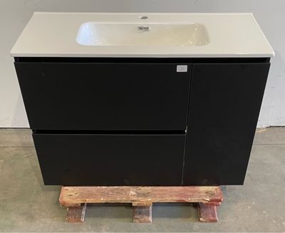 un meuble-lavabo noir avec un lavabo blanc et une palette en bois
