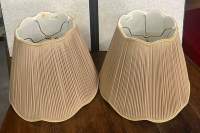 deux lampes posées sur une table en bois, avec un mur en arrière-plan