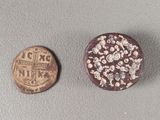 an old coin sitting next to a small coin on top of a table