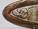 a brown and white plate with a design on it