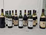 bottles of wine are lined up on a counter in front of a window