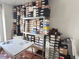 a room with a table and a lot of boxes on the shelves