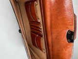 someone is holding a brown leather wallet in their hand
