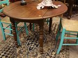 une table en bois avec quatre chaises et un vase posé dessus