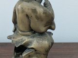 a bronze statue of a man sitting on a bench