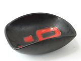 un bol noir orné d'un motif rouge à l'intérieur