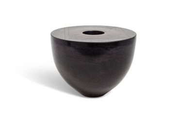 a black vase that is sitting on a white surface
