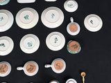 many different types of tea cups and saucers on the table