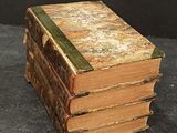 several old books stacked on top of each other on a table