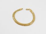 une image d'un bracelet en or sur fond blanc