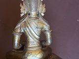 une statue représentant une personne assise sur une table