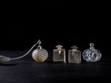three glass bottles and a spoon sitting on a table