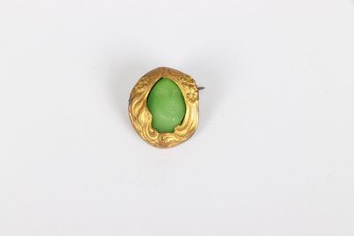 a close up of a ring with a green stone in it
