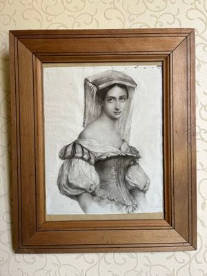 tableau représentant une femme portant un voile, dans un cadre en bois accroché au mur
