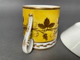 a yellow cup with a spoon sitting next to it